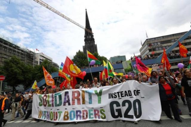 People hold flags and banner during demonstrations at the G20 summit in Hamburg